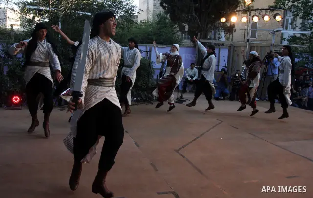 Palestinians perform folk dancing as they take part in a Palestinian wedding, during the opening of the "Heritage Week V in Birzeit 2012" in the old town of Birzeit in Ramallah, West Bank, 27 June 2012. Photo by Issam Ri...