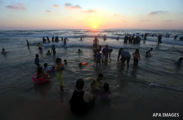 Palestinians enjoy swimming in the sea on Gaza's beach on 27 June 2012 in Gaza City . Photo by Majdi Fathi