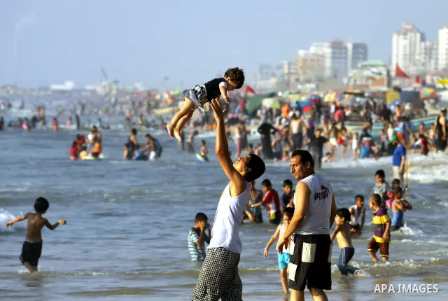 Palestinians enjoy swimming in the sea on Gaza's beach on 27 June 2012 in Gaza City . Photo by Majdi Fathi