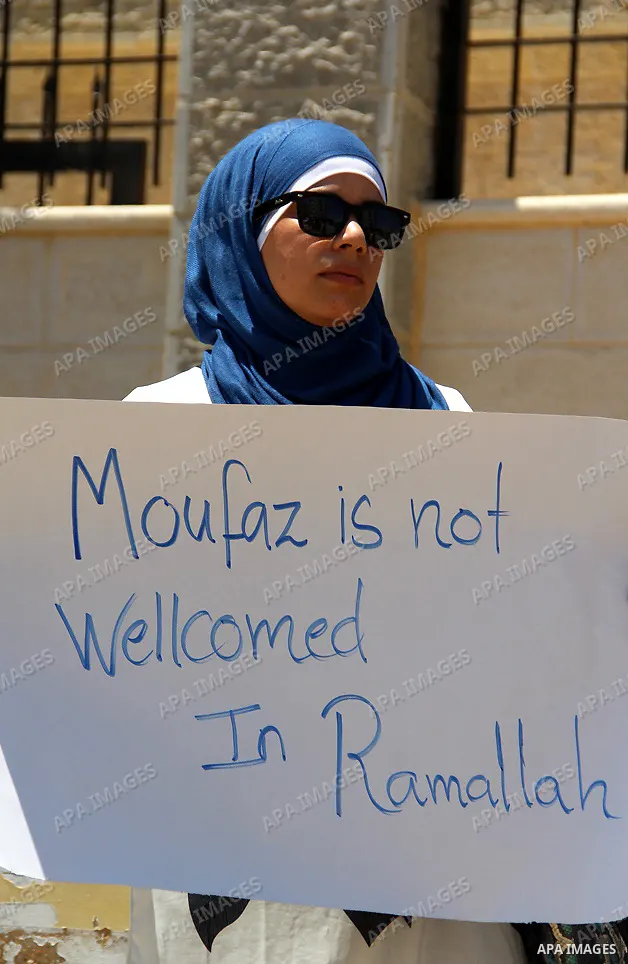 A Palestinian protestor holds a signe bearing slogans against the upcoming visit of Israeli vice prime minister Shaul Mofaz to the West Bank city of Ramallah for a meeting with Palestinian president Mahmud Abbas, outside...