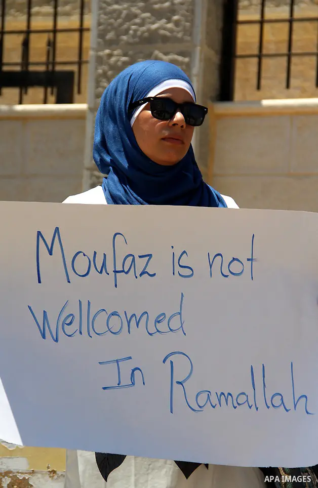 A Palestinian protestor holds a signe bearing slogans against the upcoming visit of Israeli vice prime minister Shaul Mofaz to the West Bank city of Ramallah for a meeting with Palestinian president Mahmud Abbas, outside...