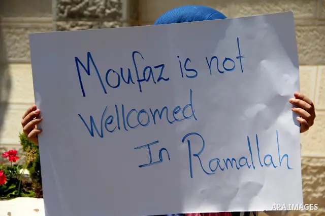 A Palestinian protestor holds a signe bearing slogans against the upcoming visit of Israeli vice prime minister Shaul Mofaz to the West Bank city of Ramallah for a meeting with Palestinian president Mahmud Abbas, outside...