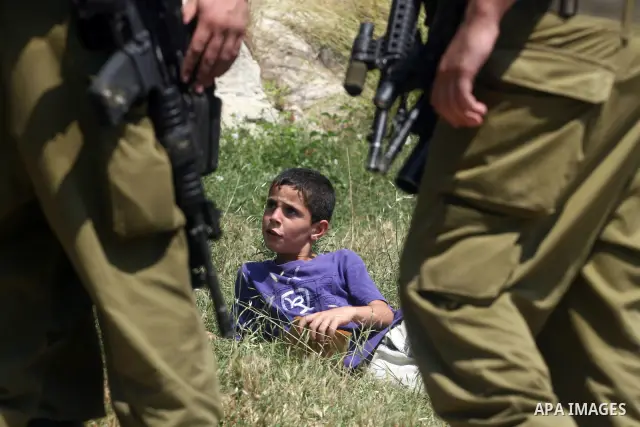 Israeli soldiers confront Palestinian child during a demonstration against Israel's separation barrier in the West Bank village of Nabi Saleh near Ramallah, Friday, June 29, 2012. Palestinians protest weekly against the...