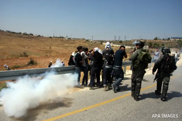 Israeli soldiers fire a tear gas canister during clashes with Palestinian protester following a weekly demonstration against Israel's separation barrier and the neighbouring Jewish settlement of Halamish in the West Bank...