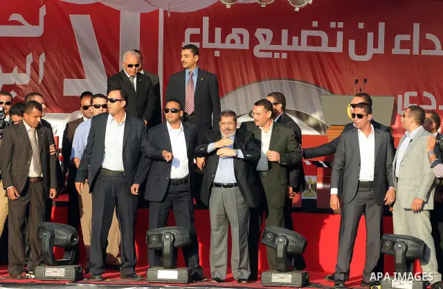 Egypt's president-elect Mohamed Morsi, surrounded by security guards, waves to protesters at the end of his speech at Tahrir square, in Cairo, Egypt, 29 June 2012. Media reports stated Morsi said on 29 June that people p...