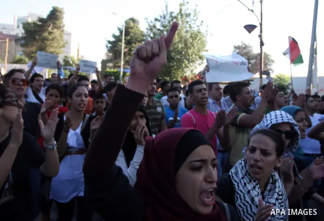 Palestinians shout slogans during a protest against a meeting between Palestinian President Mahmoud Abbas and Israeli Vice Prime Minister Shaul Mofazin, in the West Bank city of Ramallah, Saturday, June 30, 2012. A sched...
