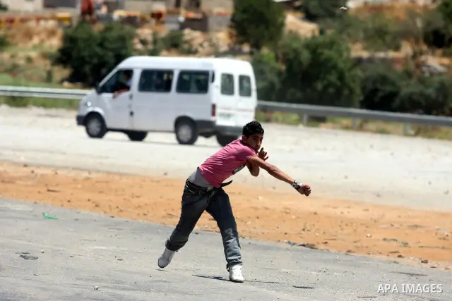 Palestinian protestors throw stones during clashes with Israeli police following a demonstration outside Ofer prison, near the West Bank city of Ramallah, in solidarity with Palestinian prisoners being held in Israeli ja...