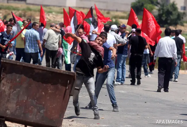 Palestinians run away from Israeli troops during a Democratic Front for the Liberation of Palestine (DFLP) demonstration supporting prisoners in Israeli jails outside the Ofer military prison, near the West Bank city of...