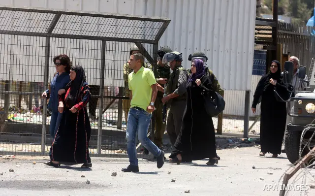 Israeli soldiers take cover during clashes with Palestinian protestors following a demonstration outside Ofer prison, near the West Bank city of Ramallah,on Sunday, July, 1, 2012. Photo by Issam Rimawi