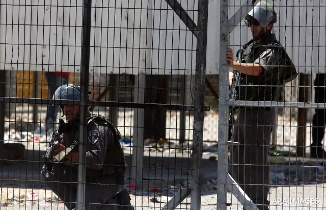 Israeli soldiers take cover during clashes with Palestinian protestors following a demonstration outside Ofer prison, near the West Bank city of Ramallah,on Sunday, July, 1, 2012. Photo by Issam Rimawi