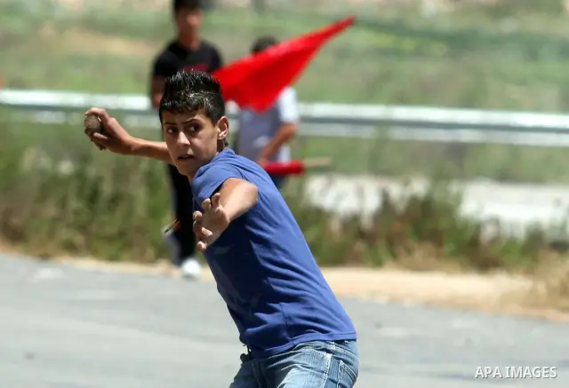 Palestinian protestors throw stones during clashes with Israeli police following a demonstration outside Ofer prison, near the West Bank city of Ramallah, in solidarity with Palestinian prisoners being held in Israeli ja...