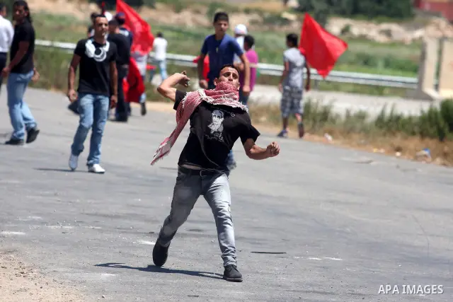 Palestinian protestors throw stones during clashes with Israeli police following a demonstration outside Ofer prison, near the West Bank city of Ramallah, in solidarity with Palestinian prisoners being held in Israeli ja...