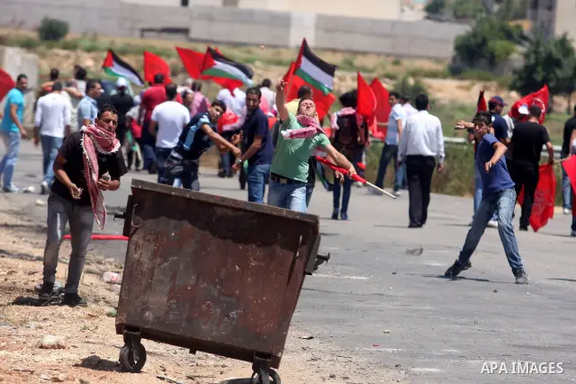 Palestinians run away from Israeli troops during a Democratic Front for the Liberation of Palestine (DFLP) demonstration supporting prisoners in Israeli jails outside the Ofer military prison, near the West Bank city of...