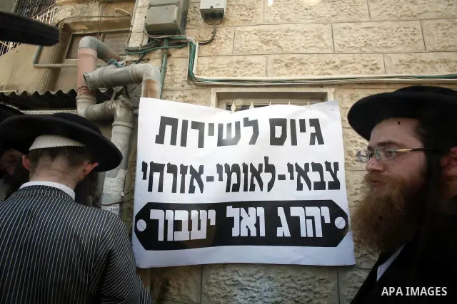 Ultra-Orthodox Jewish hold banners with slogans against involvement in the Israeli army during a protest in the west Jerusalem, on 01 July 2012. Photo by Mahfouz Abu Turk