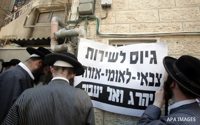 Ultra-Orthodox Jewish hold banners with slogans against involvement in the Israeli army during a protest in the west Jerusalem, on 01 July 2012. Photo by Mahfouz Abu Turk