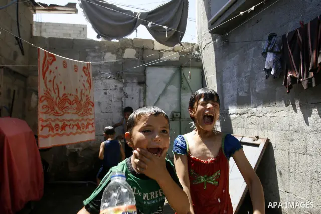 Palestinian children enjoy themselves with water during hot weather and high temperature in the southern Gaza Strip town of Rafah on July 02, 2012. Photo by Eyad Al Baba