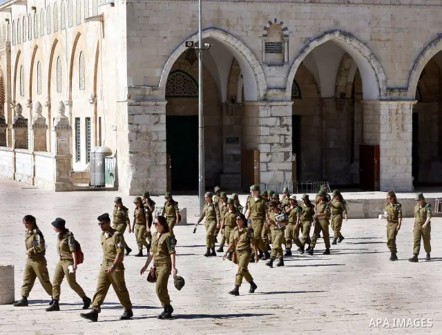 Israeli soldiers walk past the Al-Aqsa mosque compound, Islam's third holiest site, during a visit under Israeli police protection in Jerusalem's Old City on July 02, 2012. Photo by Mahfouz Abu Turk