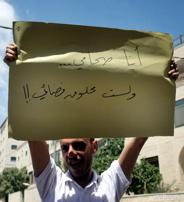 Palestinian Photojournalists hold banners and cameras outside the office of the Palestinian Interior Ministry in the West Bank city of Ramallah, July 03, 2012. Journalists protested against the assault by Palestinian pol...
