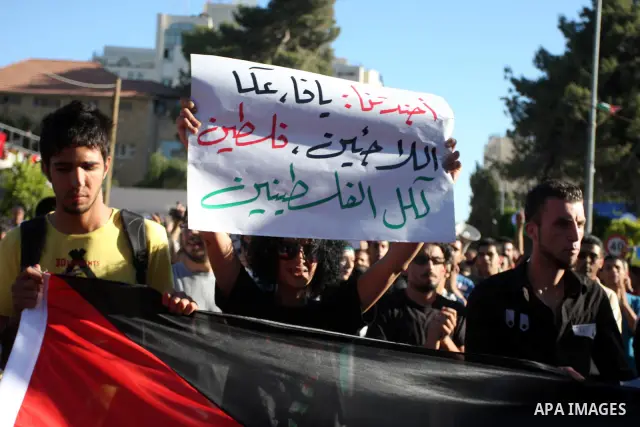 Palestinian demonstrators hold a national flag in the West Bank city of Ramallah on July 3, 2012 to protest against the violent dispersal of two similar rallies over the weekend. The demonstration was called by the "Pale...