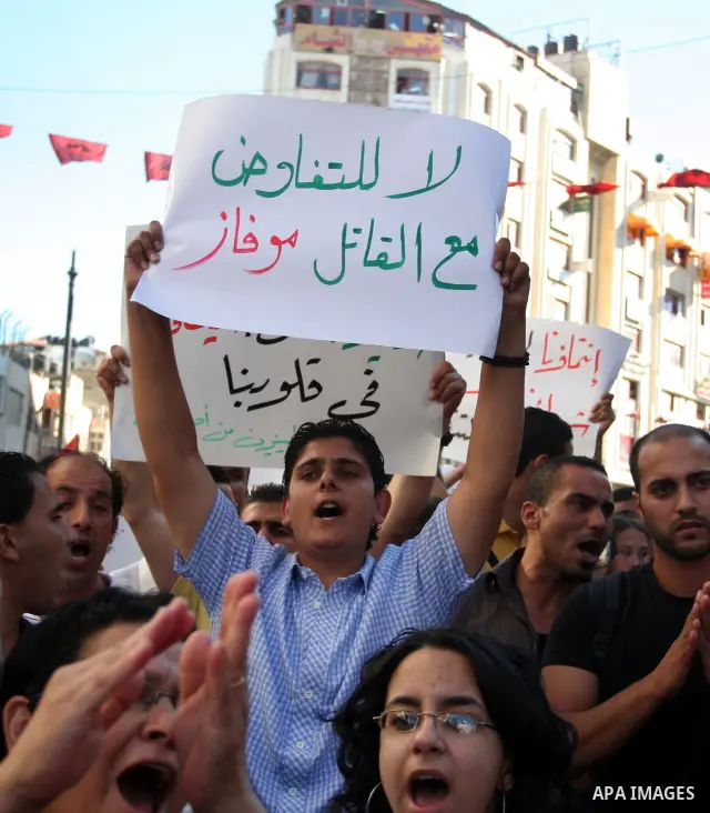 Palestinian demonstrators hold a national flag in the West Bank city of Ramallah on July 3, 2012 to protest against the violent dispersal of two similar rallies over the weekend. The demonstration was called by the "Pale...