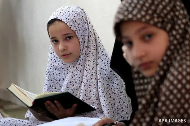 Palestinian girls read the Koran at a summer camp in the Gaza Strip, 04 July 2012. About 20,000 students, both male and female, study under the tuition of 1,200 teachers at the camp. Hamas usually isolates boys and girls...