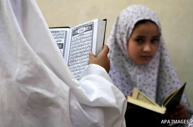 Palestinian girls read the Koran at a summer camp in the Gaza Strip, 04 July 2012. About 20,000 students, both male and female, study under the tuition of 1,200 teachers at the camp. Hamas usually isolates boys and girls...