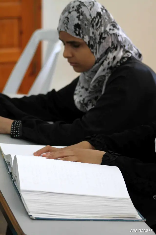 A blind Palestinian woman reads the Koran at a summer camp in the Gaza Strip, 04 July 2012. About 20,000 students, both male and female, study under the tuition of 1,200 teachers at the camp. Hamas usually isolates boys...