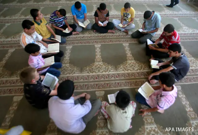 Palestinian girls read the Koran at a summer camp in the Gaza Strip, 04 July 2012. About 20,000 students, both male and female, study under the tuition of 1,200 teachers at the camp. Hamas usually isolates boys and girls...