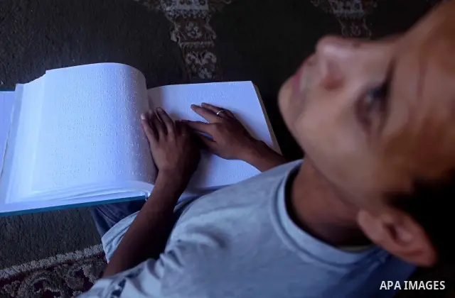 A blind Palestinian boy reads the Koran at a summer camp in the Gaza Strip, 04 July 2012. About 20,000 students, both male and female, study under the tuition of 1,200 teachers at the camp. Hamas usually isolates boys an...