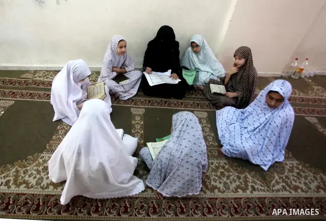 Palestinian girls read the Koran at a summer camp in the Gaza Strip, 04 July 2012. About 20,000 students, both male and female, study under the tuition of 1,200 teachers at the camp. Hamas usually isolates boys and girls...