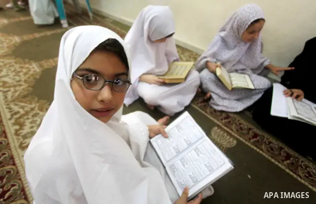 Palestinian girls read the Koran at a summer camp in the Gaza Strip, 04 July 2012. About 20,000 students, both male and female, study under the tuition of 1,200 teachers at the camp. Hamas usually isolates boys and girls...