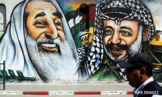 A Palestinian man walks past a mural depicting late Hamas spiritual leader Sheikh Ahmed Yassin (L) and late Palestinian leader Yasser Arafat (R) in Gaza City on July 4, 2012. Arafat, who died in 2004, was poisoned by pol...