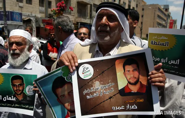 Palestinian supporters of the Islamic militant movement of Hamas, hold pictures of their relatives jailed at the Palestinian authority prisons as they protest close to president Mahmud Abbas' headquarters, in the West Ba...