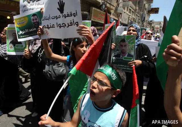 Palestinian supporters of the Islamic militant movement of Hamas, hold pictures of their relatives jailed at the Palestinian authority prisons as they protest close to president Mahmud Abbas' headquarters, in the West Ba...