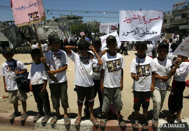 Palestinian boys hold pictures of Palestinian prisoners in the Palestinian Authority jails during a demonstration demands to release them, in the southern Gaza Strip town of Rafah on July 05, 2012. Photo by Eyad Al Baba