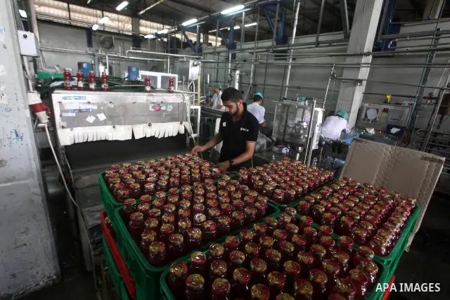Palestinian workers bottle fruit juice at Juice Factory in Gaza City on July 5, 2011. it depends on citrus and fruit that are widely planted in Gaza Strip. Photo by Ashraf Amra