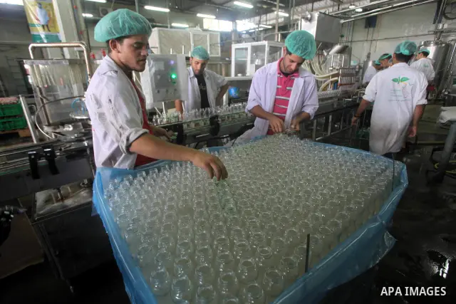 Palestinian workers bottle fruit juice at Juice Factory in Gaza City on July 5, 2011. it depends on citrus and fruit that are widely planted in Gaza Strip. Photo by Ashraf Amra