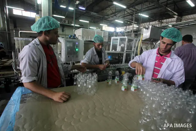 Palestinian workers bottle fruit juice at Juice Factory in Gaza City on July 5, 2011. it depends on citrus and fruit that are widely planted in Gaza Strip. Photo by Ashraf Amra