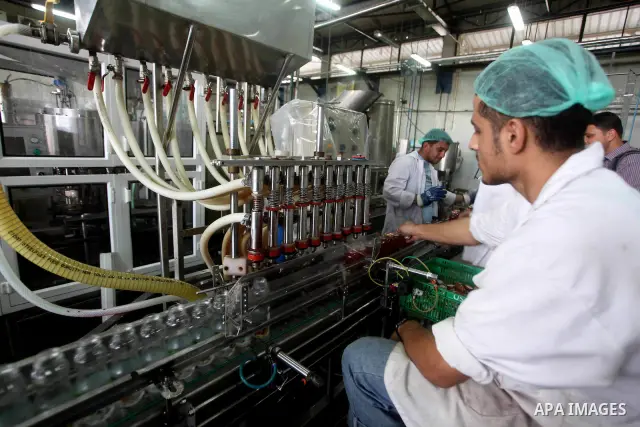 Palestinian workers bottle fruit juice at Juice Factory in Gaza City on July 5, 2011. it depends on citrus and fruit that are widely planted in Gaza Strip. Photo by Ashraf Amra