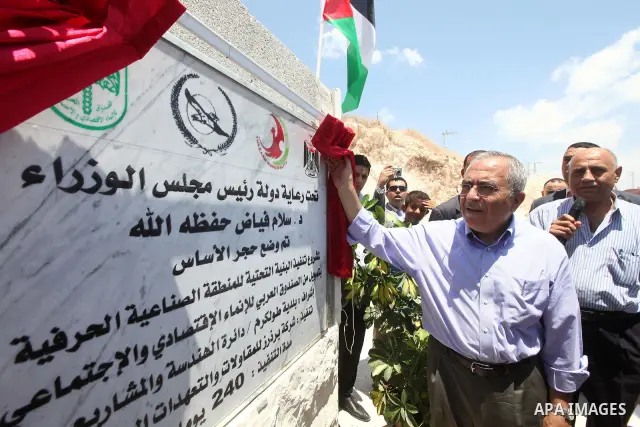 Palestinian Prime Minister Salam Fayyad puts the foundation stone of the infrastructure of the industrial ??craft area of in the neighborhood of Irtah, in the West Bank city of Tulkarm on 05 July 2012. Photo by Mustafa A...
