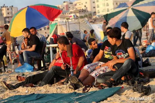 Palestinian youths smoke the water pipes on the beach on their week-end in the Mediterranean sea in Gaza City on July 06, 2012. Photo by Ashraf Amra