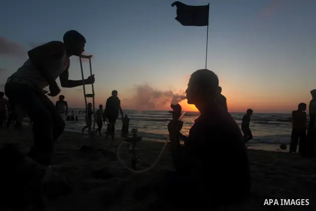 Palestinian youths smoke the water pipes on the beach on their week-end in the Mediterranean sea in Gaza City on July 06, 2012. Photo by Ashraf Amra