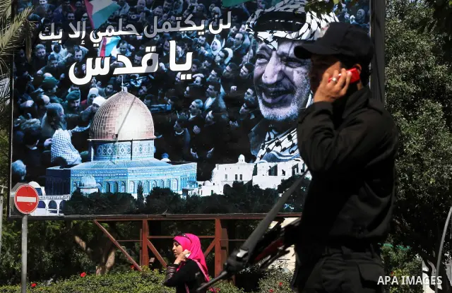 Palestinian police stands next to a huge poster of late Palestinian leader Yasser Arafat in Gaza City on July 7, 2012. The Palestinian National Authority (PNA) has agreed to exhume late President Yasser Arafat's body for...