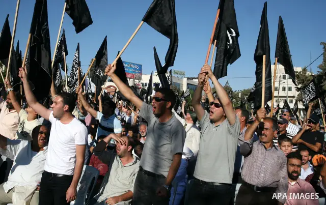Palestinian supporters of Hizb ut-Tahrir or the Islamic Liberation Party, chant slogans and wave black and white flags with the religous writing "There is no God but God, and Mohammed is his prophet" during a rally in th...