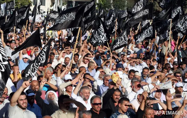 Palestinian supporters of Hizb ut-Tahrir or the Islamic Liberation Party, chant slogans and wave black and white flags with the religous writing "There is no God but God, and Mohammed is his prophet" during a rally in th...