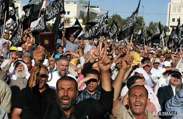 Palestinian supporters of Hizb ut-Tahrir or the Islamic Liberation Party, chant slogans and wave black and white flags with the religous writing "There is no God but God, and Mohammed is his prophet" during a rally in th...