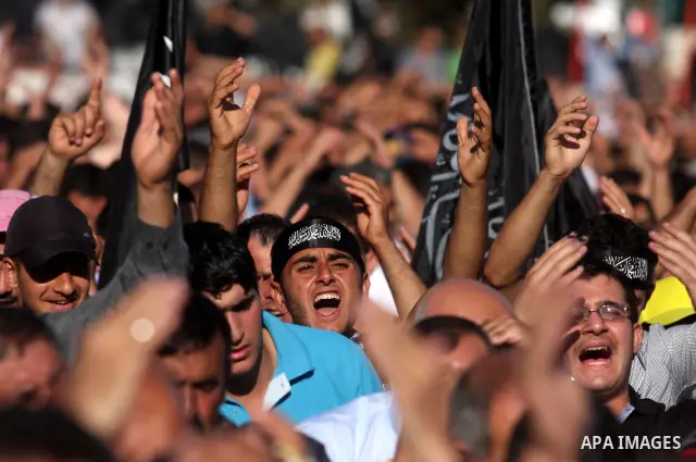 Palestinian supporters of Hizb ut-Tahrir or the Islamic Liberation Party, chant slogans and wave black and white flags with the religous writing "There is no God but God, and Mohammed is his prophet" during a rally in th...