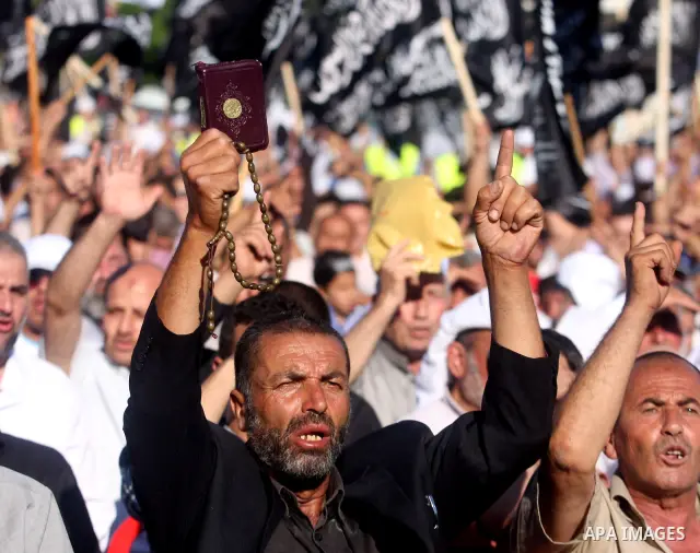 Palestinian supporters of Hizb ut-Tahrir or the Islamic Liberation Party, chant slogans and wave black and white flags with the religous writing "There is no God but God, and Mohammed is his prophet" during a rally in th...