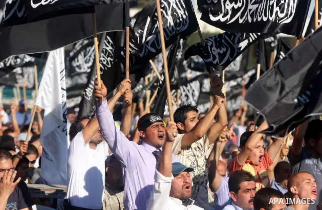Palestinian supporters of Hizb ut-Tahrir or the Islamic Liberation Party, chant slogans and wave black and white flags with the religous writing "There is no God but God, and Mohammed is his prophet" during a rally in th...
