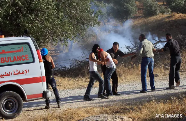 Palestinians run from tear gas fired by Israeli soldiers after two shepherds from the village of Aqraba, south of the city of Nablus in the Israeli occupied West Bank were allegedly attacked by Jewish settlers from the I...